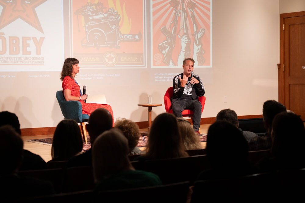 Shepard Fairey and Renee Maurer giving a talk in an auditorium
